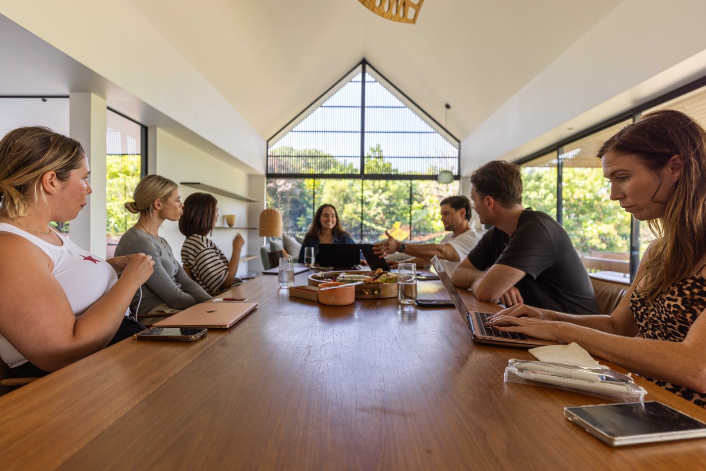 The Buywell team in a strategy session around a long timber table