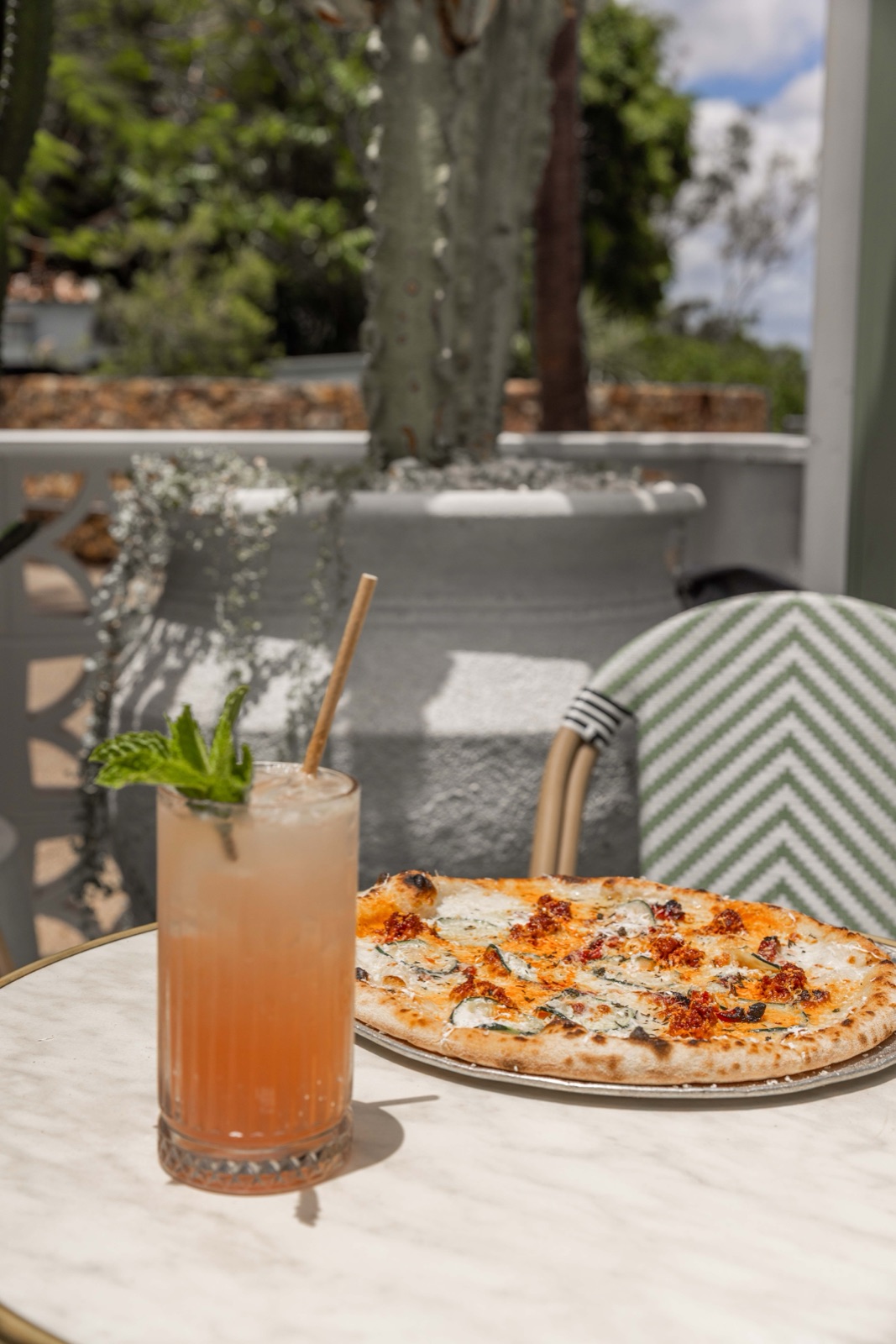 Pizza and a fresh cocktail on a marble table at Joeys Brisbane restaurant, captured for the venue's summer Instagram content.
