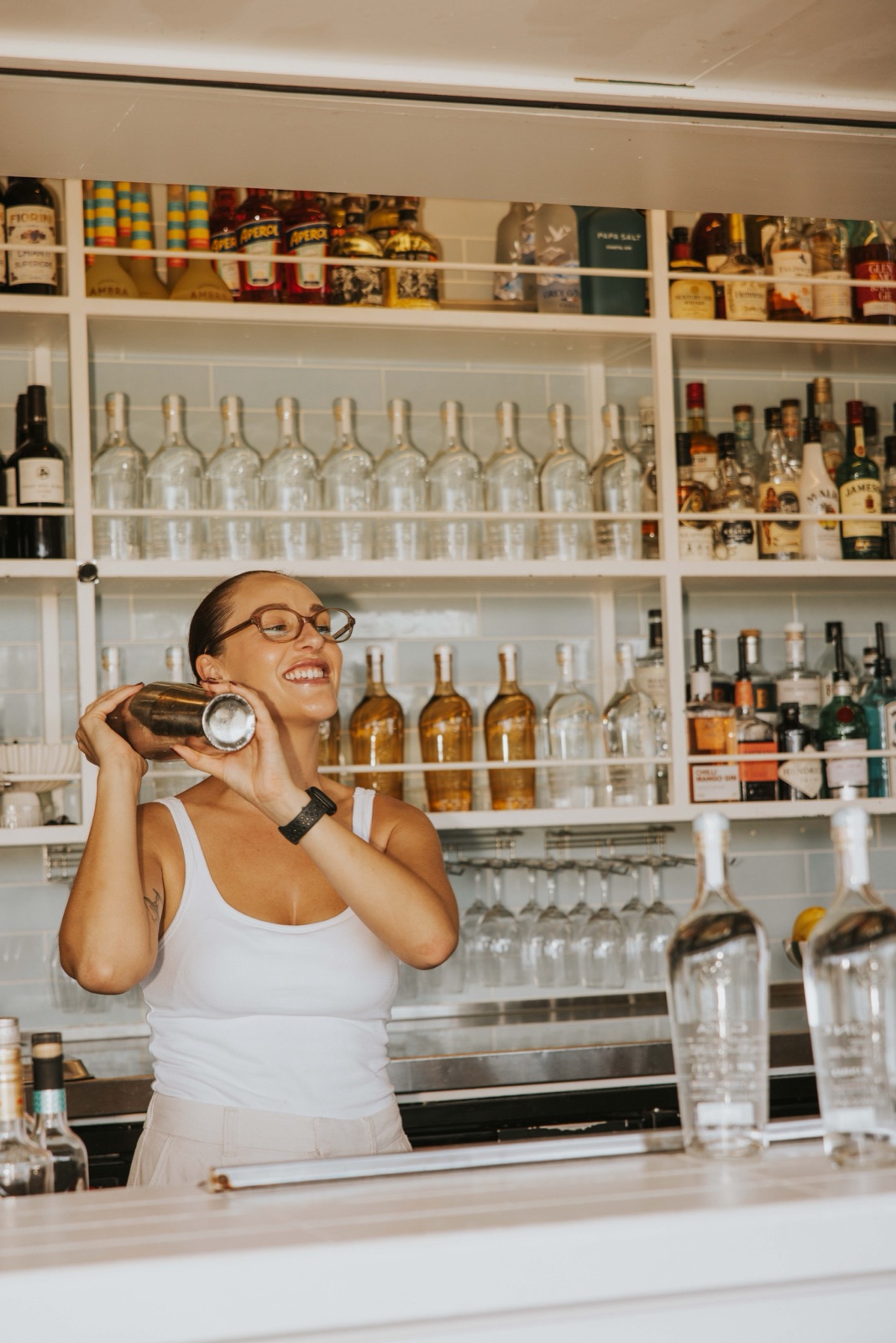 Cinca, a bartender at Joeys Brisbane, mixing a cocktail behind a fully stocked back bar.