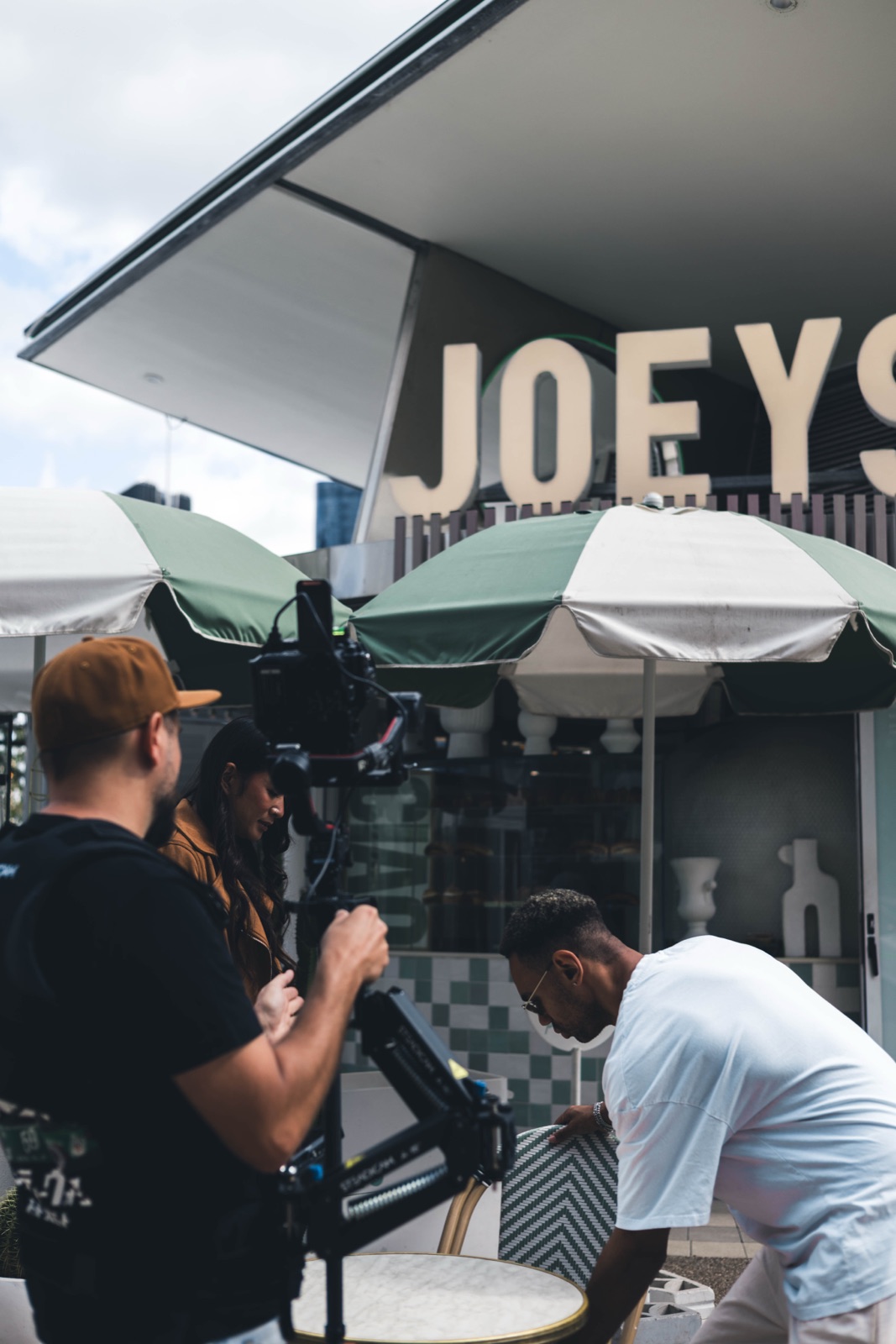 Bris.Social camera team setting up a Ronin gimbal rig for a content shoot under the Joeys Brisbane restaurant signage.